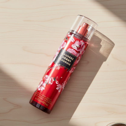 Red floral spray bottle on a wooden surface