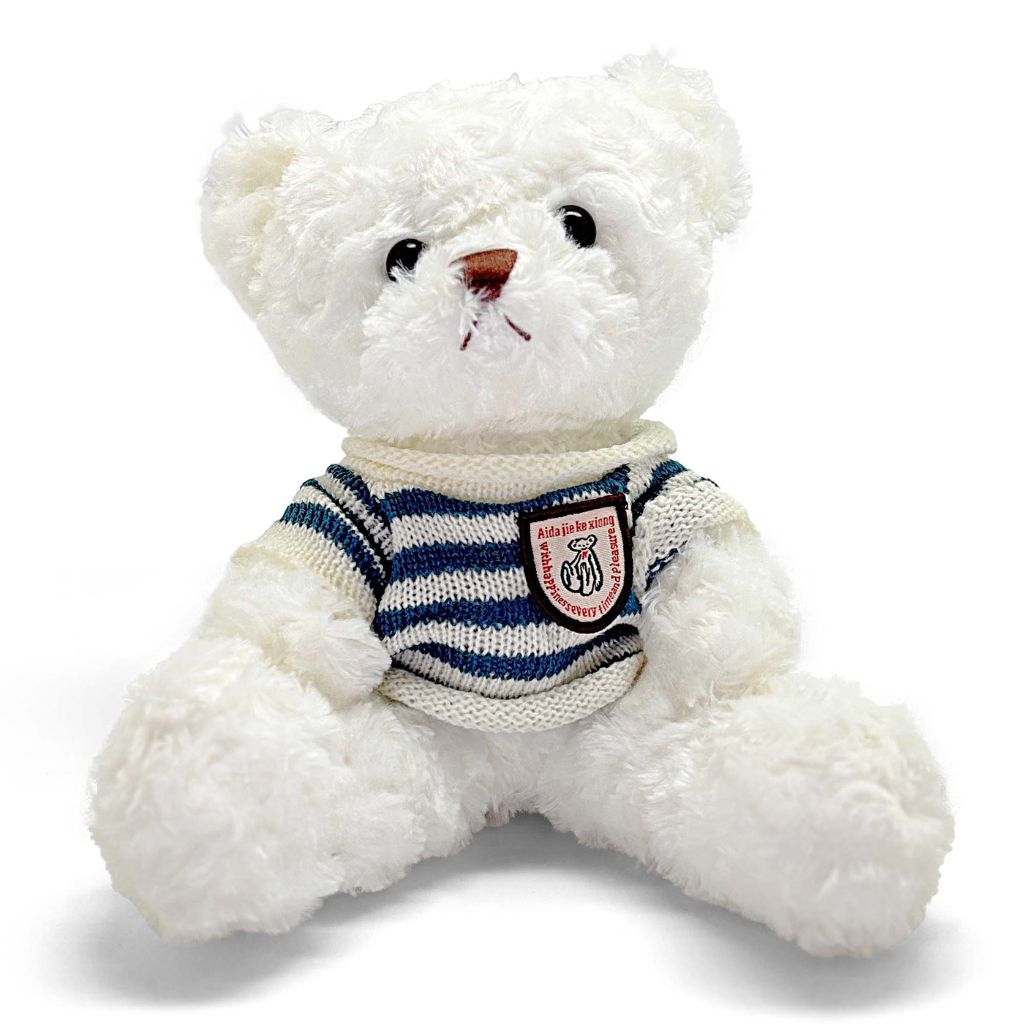 White teddy bear wearing a striped sweater with a patch on a white background