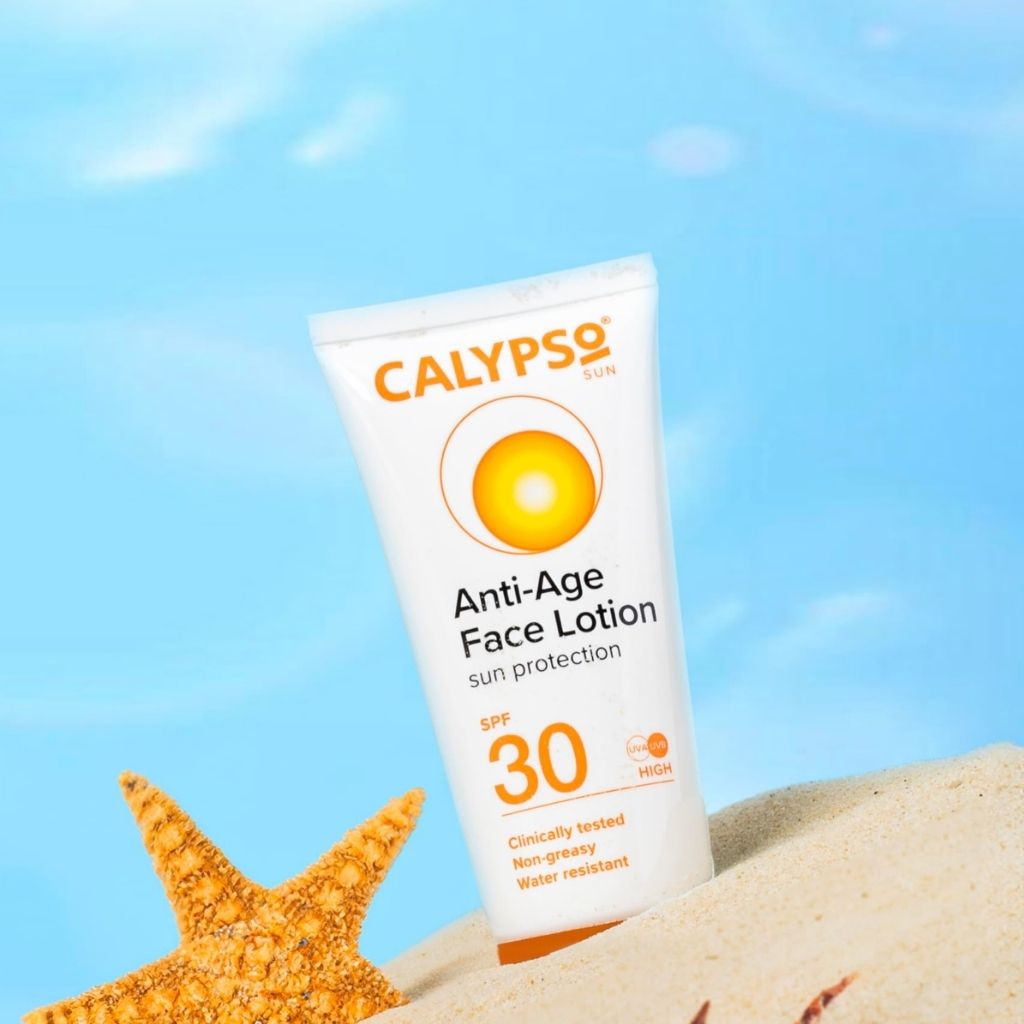 Calypso Anti-Age Face Lotion tube with sand and starfish on a blue background