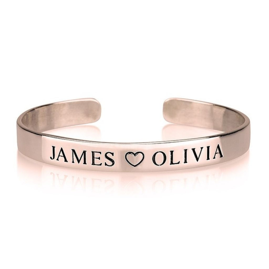 Rose gold bracelet with 'JAMES ❤️ OLIVIA' engraving on a white background