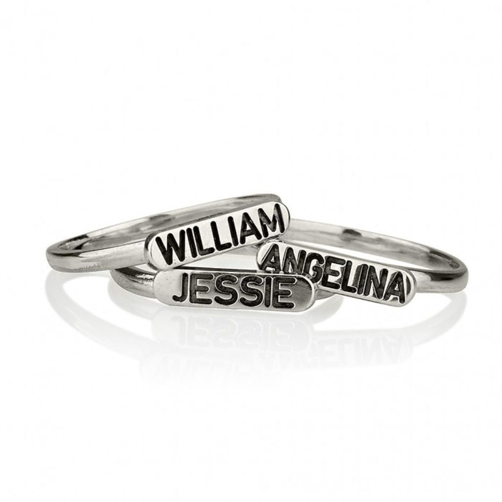 Three silver name rings with 'William', 'Angelina', and 'Jessie' on a white background