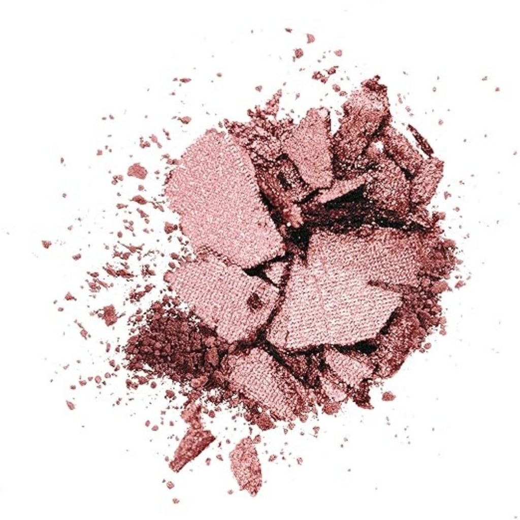 Crumbled pink makeup powder on a white background