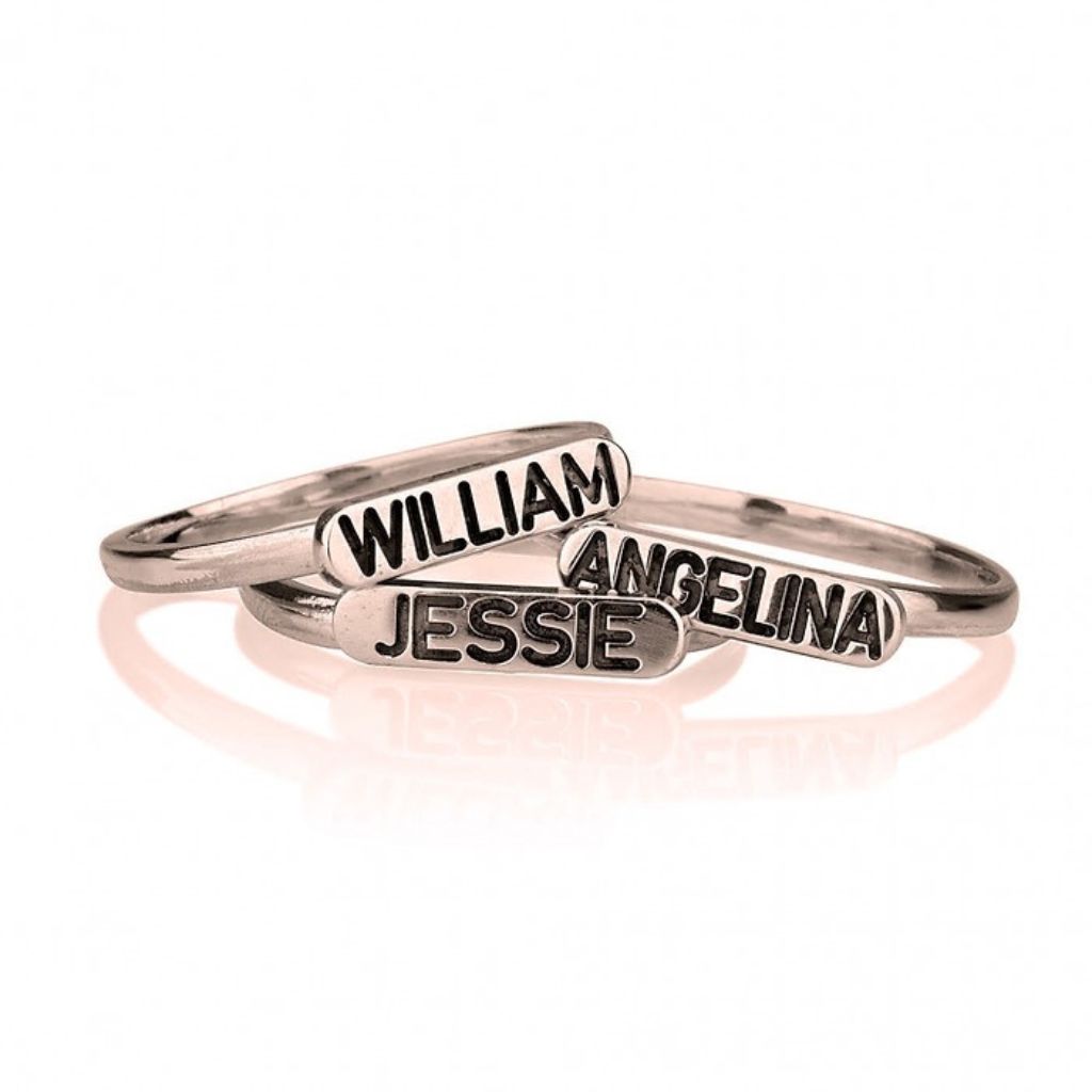 Two silver name rings with 'William', 'Angelina', and 'Jessie' engraved on a white background.