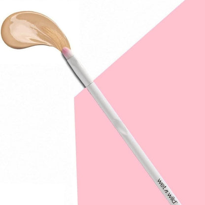 Makeup brush with beige powder on a pink background