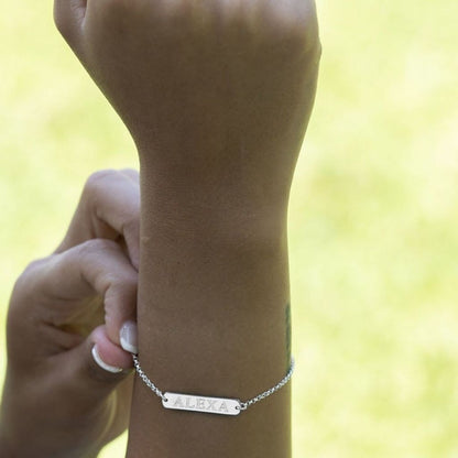 Silver bracelet on a wrist with a blurred yellow background
