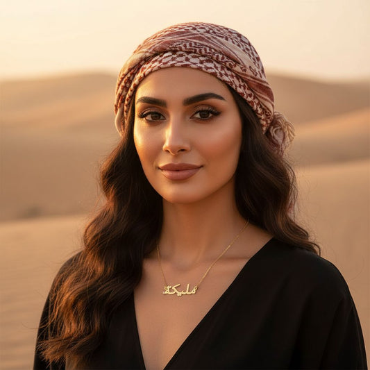 Woman wearing a patterned headscarf and black top in a desert setting