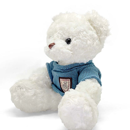 White teddy bear wearing a blue sweater with a logo on a white background