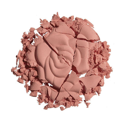 Crumbled pink makeup product on a white background