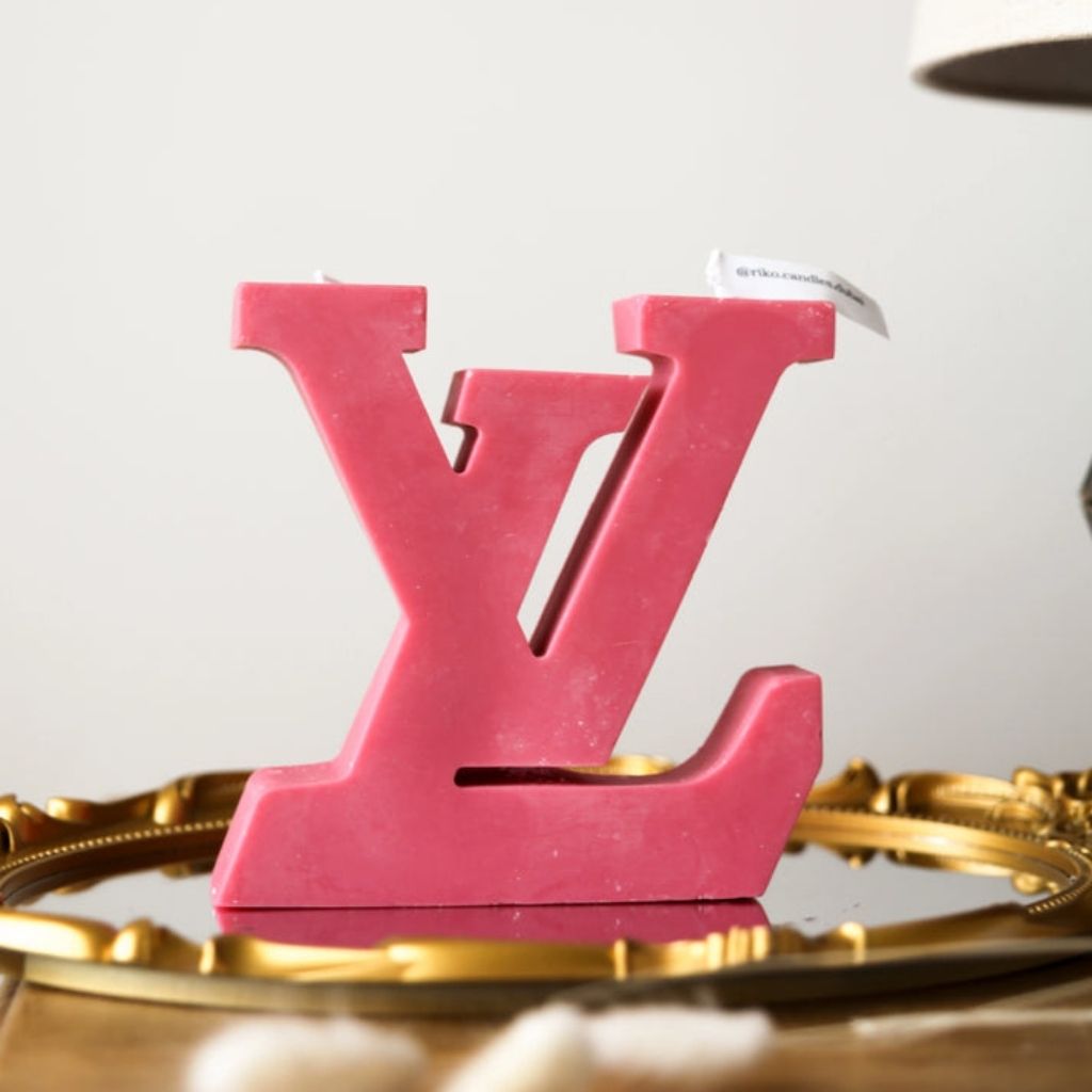 Pink 'LV' logo on a gold base with a white background