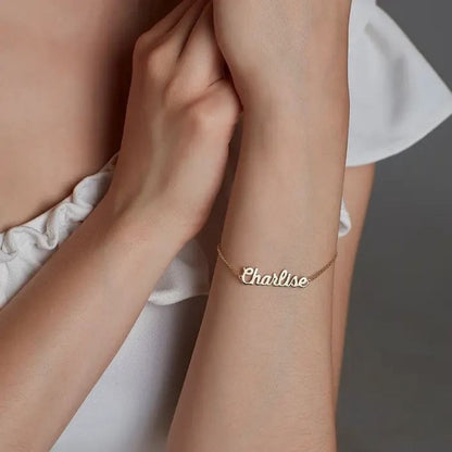 Gold bracelet with 'Charline' on a person's wrist against a neutral background