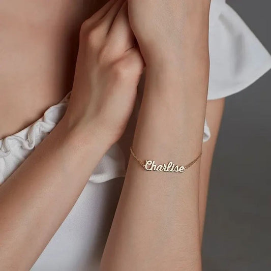 Gold bracelet with 'Charline' on a person's wrist against a neutral background