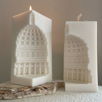 Two candles with architectural designs on a neutral background