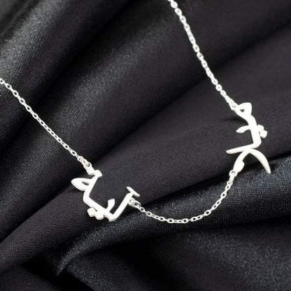 Silver necklace with leaf-like pendants on a black fabric background