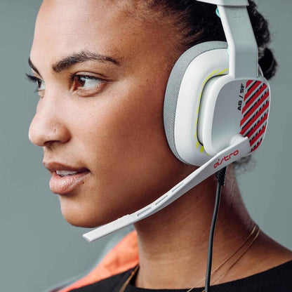 Person wearing a white gaming headset with red and yellow accents on a gray background