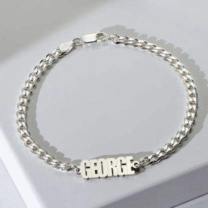 Silver chain bracelet with 'GEORGE' on a light gray background