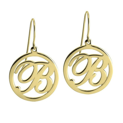Gold earrings with circular design and cut-out letters on a white background