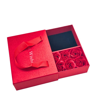Red gift box with a red ribbon and red roses on a white background