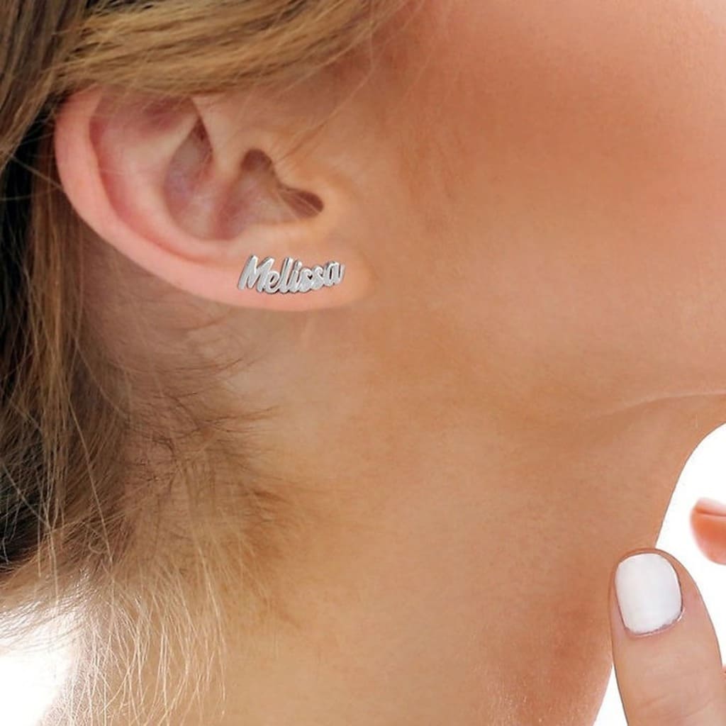 Silver 'Melissa' earring worn by a person with a blurred background