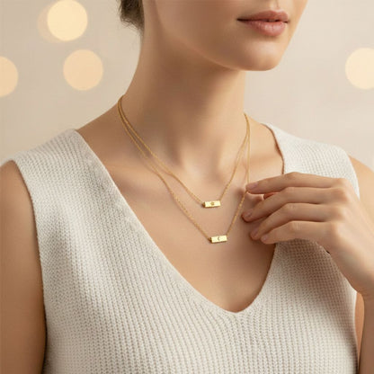 Woman wearing a gold necklace with a soft focus background