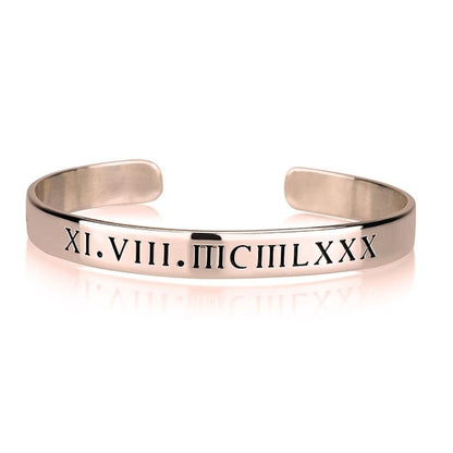Rose gold bracelet with Roman numeral engraving on a white background