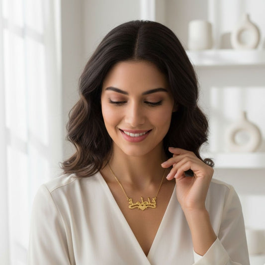 Woman wearing a gold necklace with a heart design in a bright room