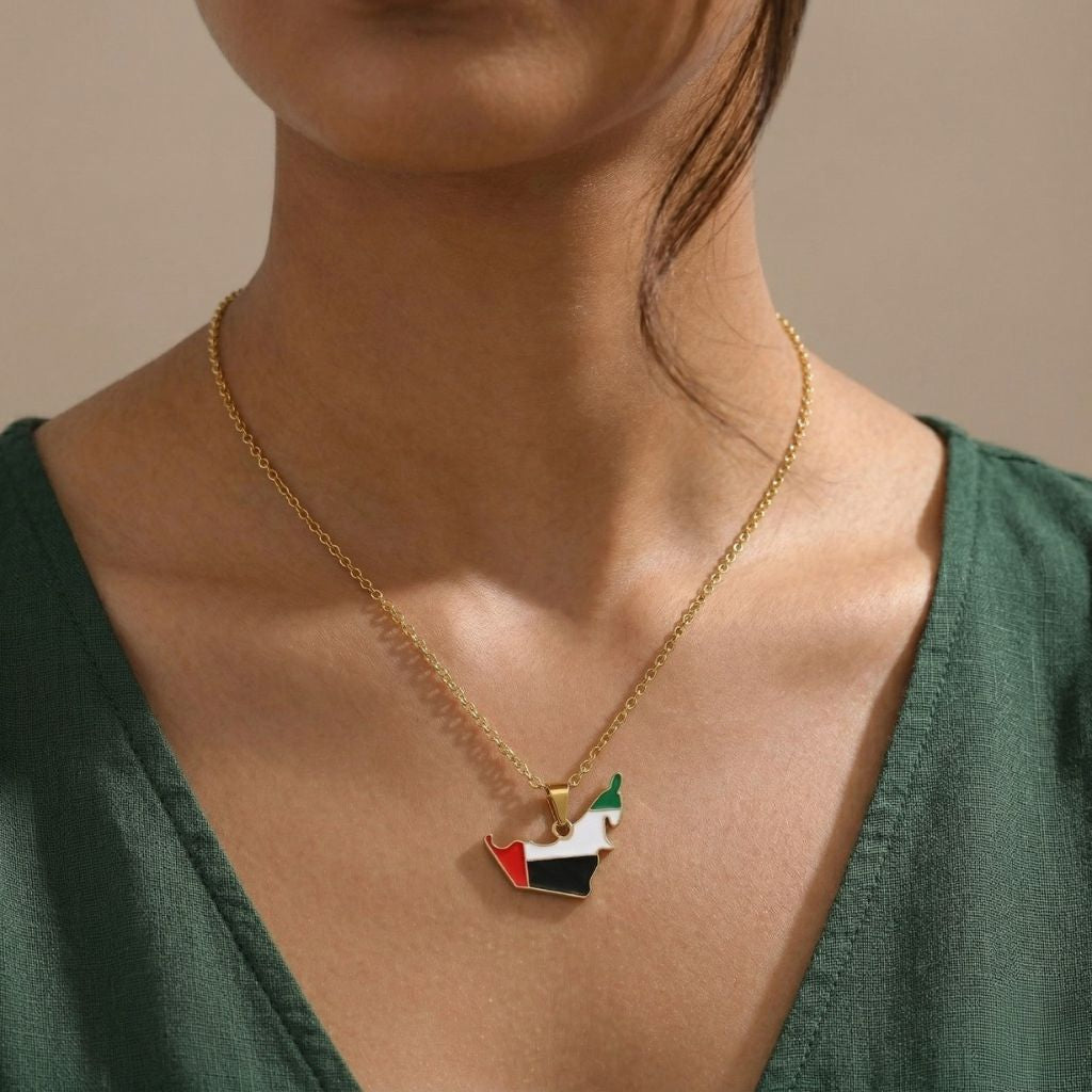 Necklace with a pendant shaped like the flag of United Arab Emirates worn by a person.