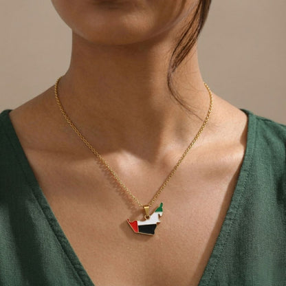 Necklace with a pendant shaped like the flag of United Arab Emirates worn by a person.