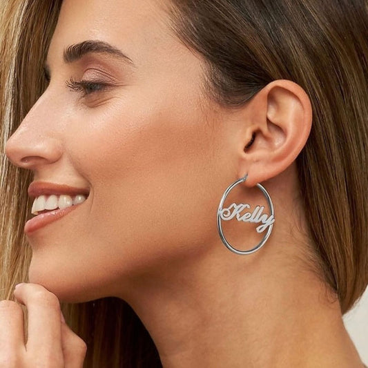 Woman wearing a silver hoop earring with 'Kelly' engraved.