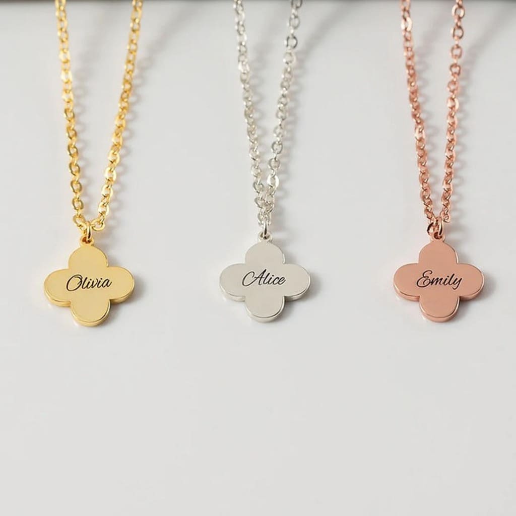 Three name necklaces on gold, silver, and rose gold chains with engraved names.