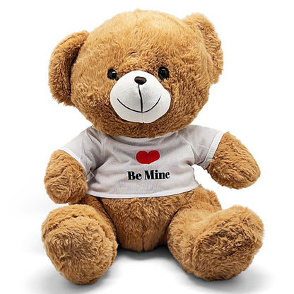 Brown teddy bear wearing a white shirt with a red heart and 'Be Mine' text on a white background