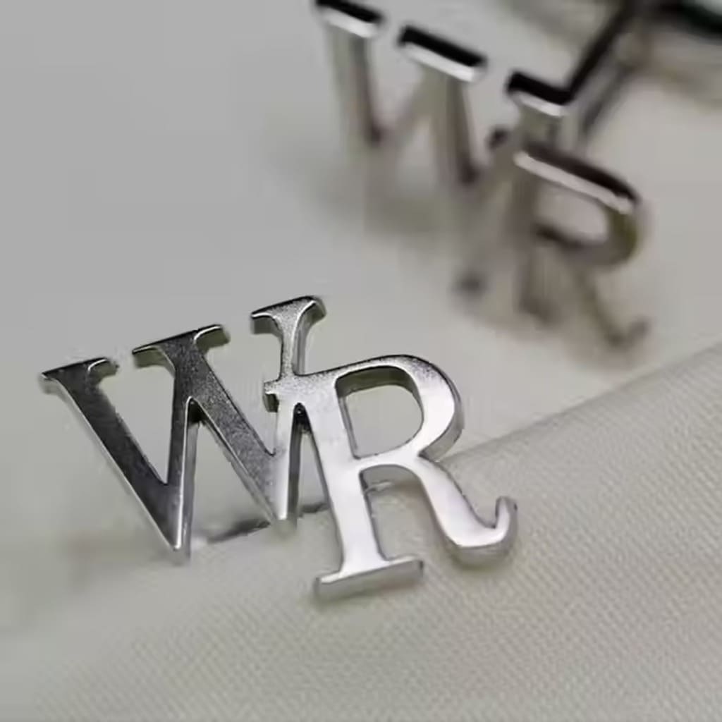 Silver earrings with 'WR' initials on a light background