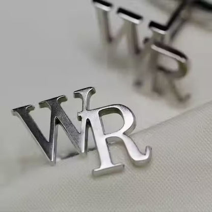 Silver earrings with 'WR' initials on a light background
