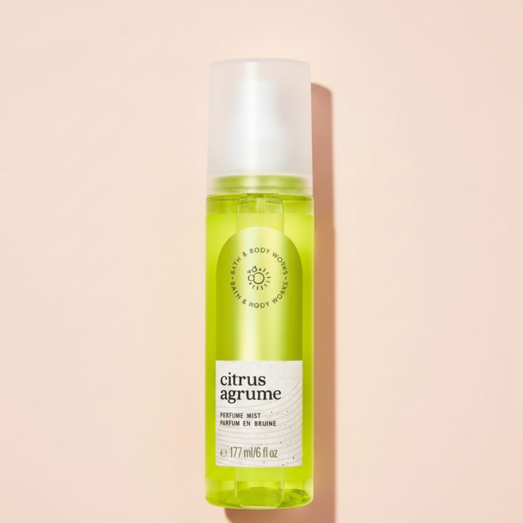 Green perfume mist bottle labeled 'citrus agrume' on a beige background
