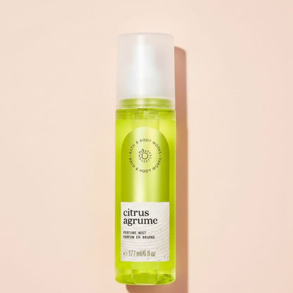 Green perfume mist bottle labeled 'citrus agrume' on a beige background