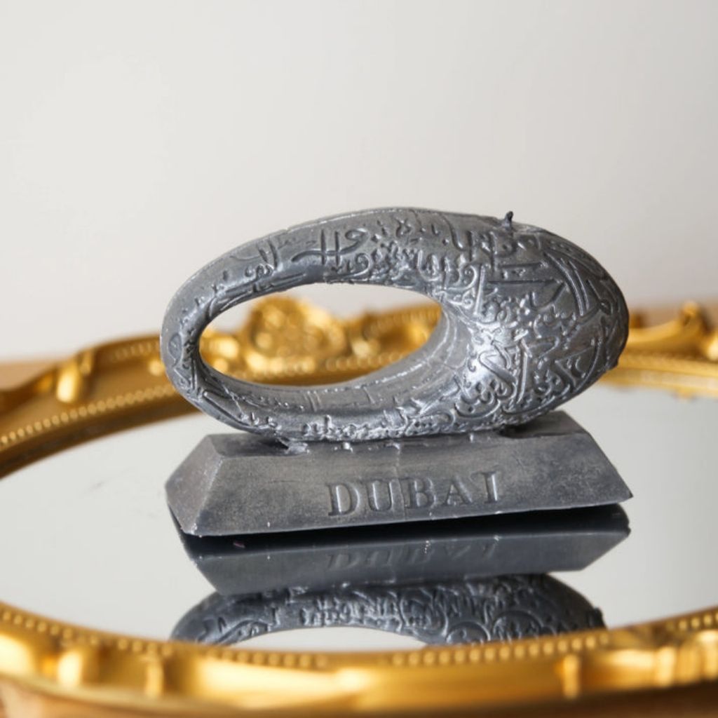 Decorative object with 'Dubai' branding on a reflective surface