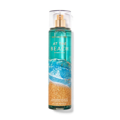 Bottle of 'At the Beach' body spray with a beach-themed design on a white background