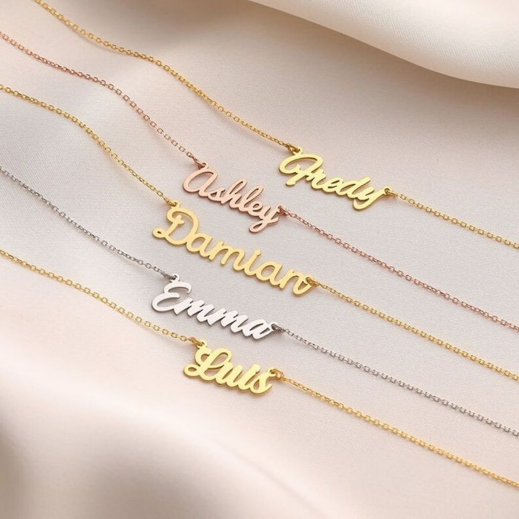 Gold and silver name necklaces on a light background