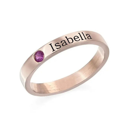 Rose gold ring with 'Isabella' engraving and purple gemstone on a white background