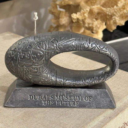 Decorative object with engraved patterns on a stand labeled 'Dubai's Museum of the Future'.