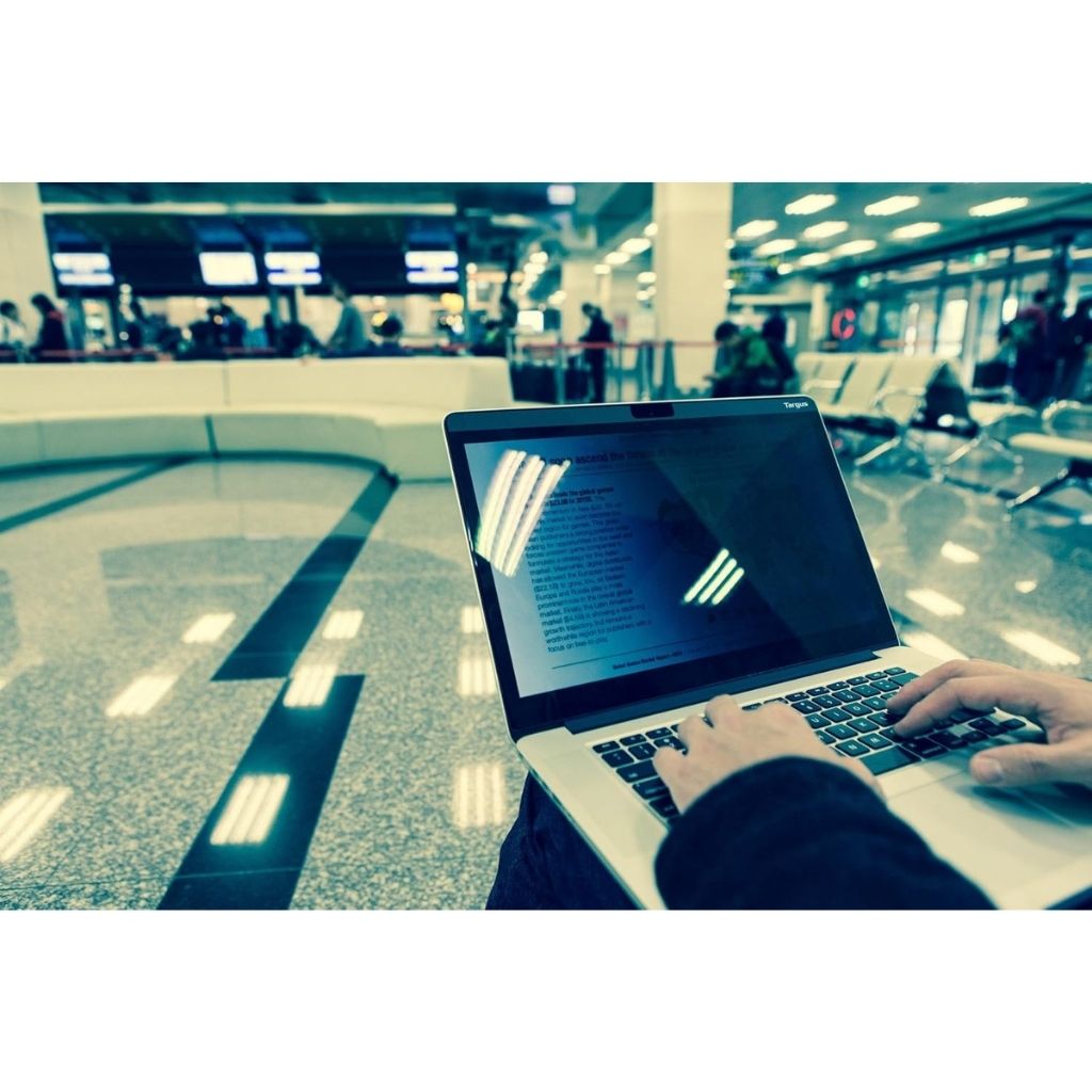 Person using a laptop in an airport terminal