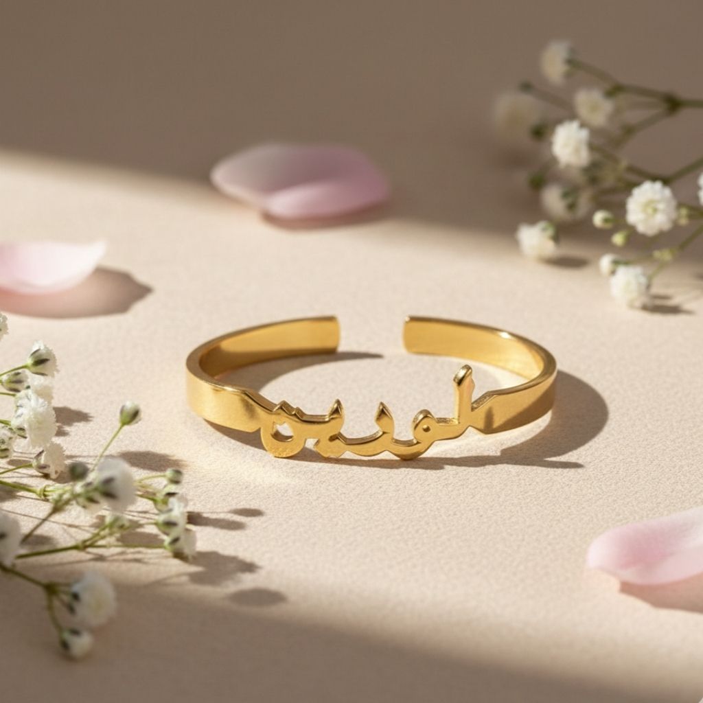 Gold bracelet with Arabic script on a beige surface with flowers