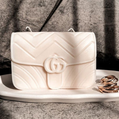White quilted handbag with a brand logo on a gray surface