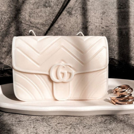 White quilted handbag with a brand logo on a gray surface