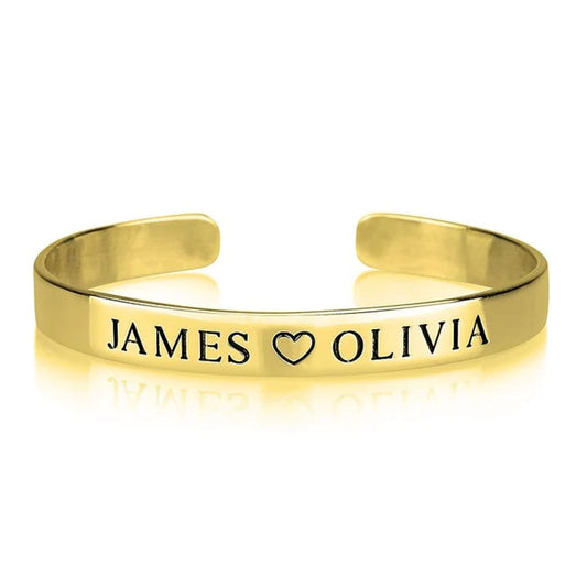 Gold bracelet with 'JAMES ❤️ OLIVIA' engraving on a white background