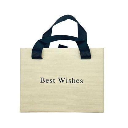 Beige gift bag with black text 'Best Wishes' and black handles on a white background