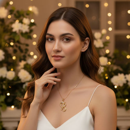 Woman wearing a gold necklace with a 'B' pendant in a decorated indoor setting.