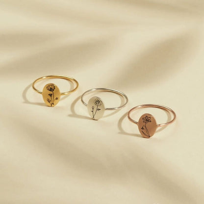 Three rings in gold, silver, and rose gold on a beige background