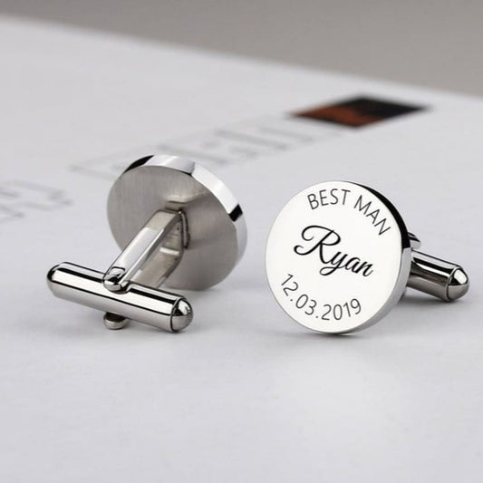 Silver cufflinks with engraved text on a light background