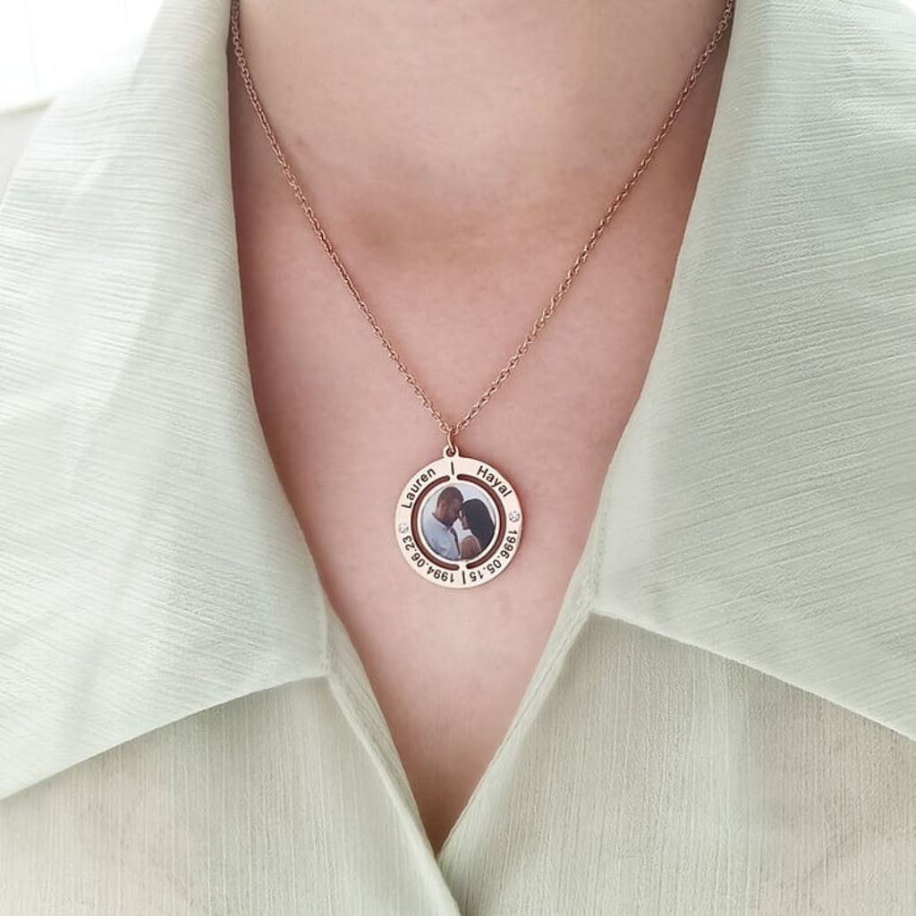 Necklace with a pendant featuring a couple's photo on a light green outfit.