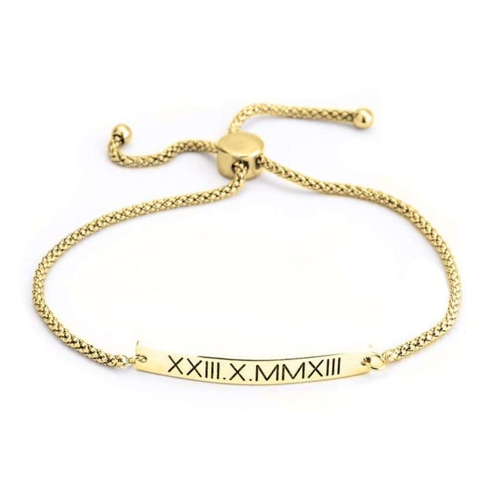 Gold bracelet with a bar featuring Roman numerals on a white background